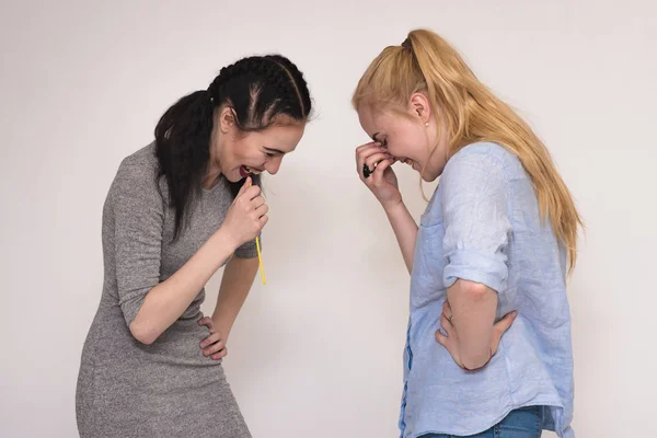 Portraits sur le fond gris de deux filles copines montrant des émotions . — Photo