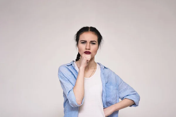 Retrato de una hermosa morena sobre un fondo gris mostrando emociones . — Foto de Stock