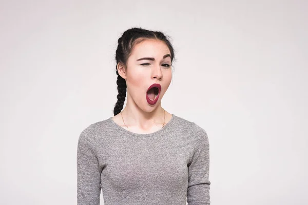 Retrato de una hermosa chica morena sobre un fondo gris mostrando brillantes emociones — Foto de Stock