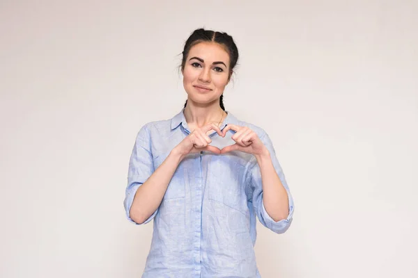 Retrato de una hermosa morena sobre un fondo gris mostrando emociones — Foto de Stock