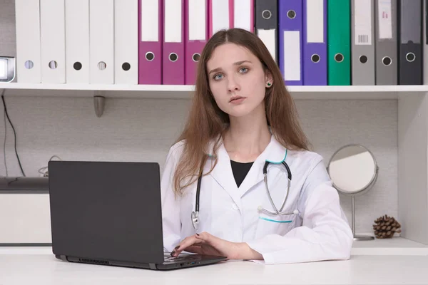 Ritratto di una dottoressa con un computer portatile a tavola — Foto Stock