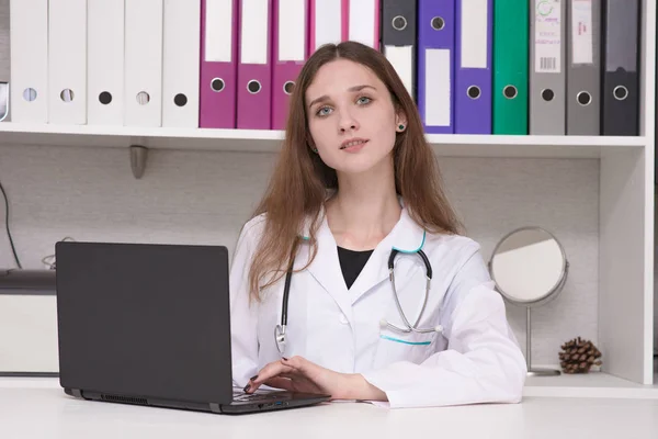Ritratto di una dottoressa con un computer portatile a tavola — Foto Stock