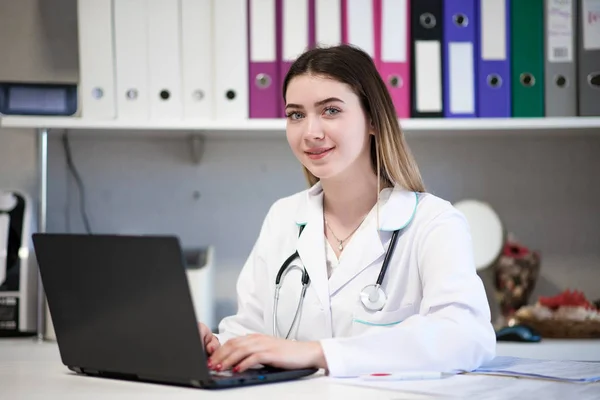 Portrait of a female doctor in the office sitting at the laptop. — Stock Photo, Image