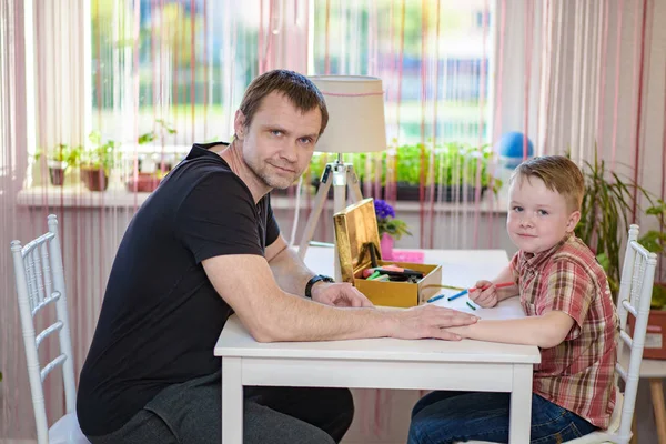 Батько і син у віці 6 років сидять за столом — стокове фото