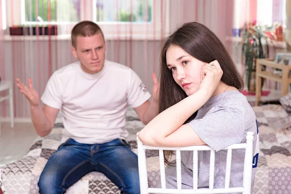 family conflict, quarrel. Portrait of husband and wife during family difficulties, conflict. They sit right in front of the camera and look unhappy