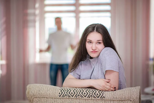 family conflict, quarrel. Portrait of husband and wife during family difficulties, conflict. They sit right in front of the camera and look unhappy