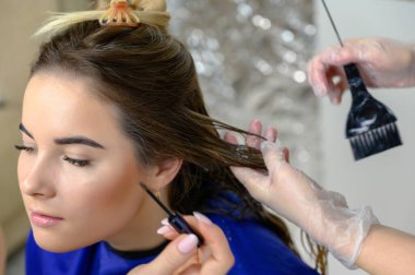 Kuaför kuaföründen bir makyözün stüdyo fotoğrafı. Güzel makyaj ve saç şekilleri yaratıyor, yüz derisini tazeliyor. Profesyonel, özel aletlerle çalışıyor..