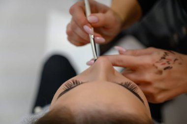 Kuaför kuaföründen bir makyözün stüdyo fotoğrafı. Güzel makyaj ve saç şekilleri yaratıyor, yüz derisini tazeliyor. Profesyonel, özel aletlerle çalışıyor..