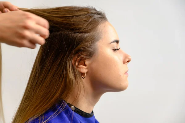 Foto de estúdio do trabalho de um maquiador por um esteticista cabeleireiro. Criando maquiagem bonita e penteados, rejuvenescendo a pele do rosto. O profissional está trabalhando com ferramentas especiais . — Fotografia de Stock