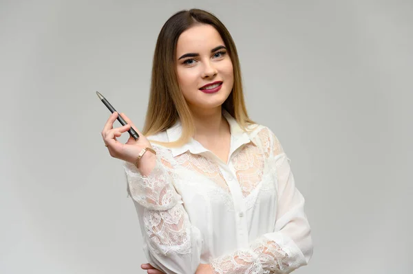 Retrato de estudio de una hermosa chica con cabello largo y hermoso y excelente maquillaje sobre un fondo gris. Está hablando con la cámara. . — Foto de Stock