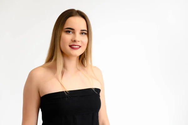 Retrato de estúdio de uma menina bonita com cabelo longo e bonito e excelente maquiagem em um fundo cinza em diferentes poses. Ela sorri. . — Fotografia de Stock