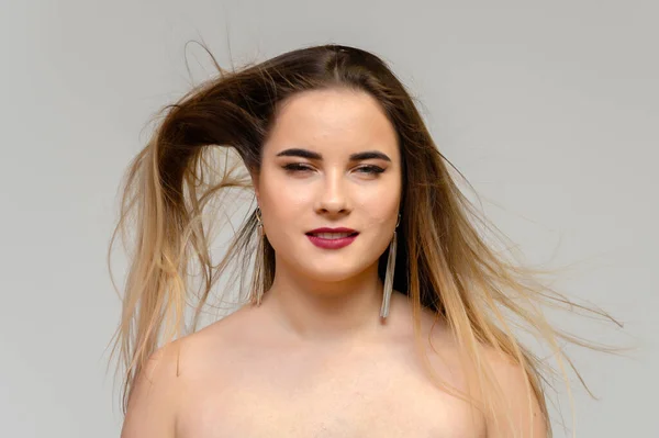 Estúdio grande foto retrato de uma menina bonita com cabelo longo e bonito fluindo e excelente maquiagem em um fundo cinza em diferentes poses. Ela sorri. . — Fotografia de Stock