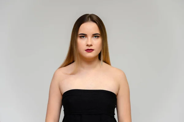 Studio grote foto portret van een mooi meisje met lang mooi stromend haar en uitstekende make-up op een grijze achtergrond in verschillende poses. Ze lacht.. — Stockfoto