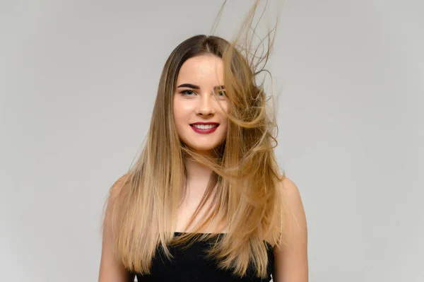 Estudio foto grande retrato de una hermosa chica con el pelo largo y hermoso que fluye y excelente maquillaje sobre un fondo gris en diferentes poses. Ella sonríe . — Foto de Stock