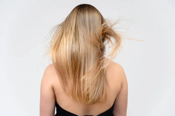 Studio large photo portrait of a beautiful girl with long beautiful fluttering hair on a white background. Back view. — Stock Photo, Image