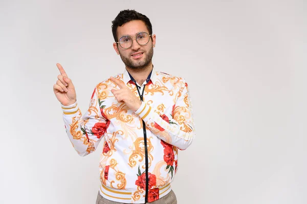 Concepto de moda para hombre. Retrato de un guapo modelo masculino mostrando las manos con una chaqueta floral blanca posando sobre un fondo blanco. Pelo negro. Cerrar Studio Shot —  Fotos de Stock