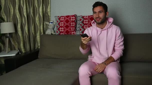 Ein Junger Mann Sitzt Gut Gelaunt Hause Auf Einem Sofa — Stockvideo