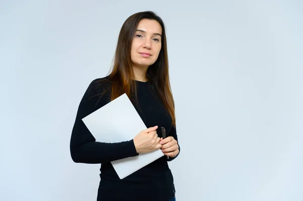 Ritratto di donna adulta senza trucco con pelle pulita, con lunghi capelli castani sul viso su sfondo bianco. Sta davanti alla telecamera con una maglietta nera, mostra le sue emozioni alle mani . — Foto Stock