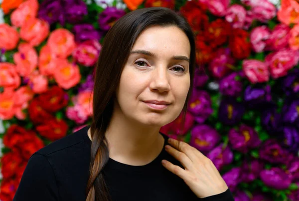 Portrait of an adult woman without makeup with clean skin, with long brown face hair on a colored background. The concept of age-related cosmetics, facial skin healing.