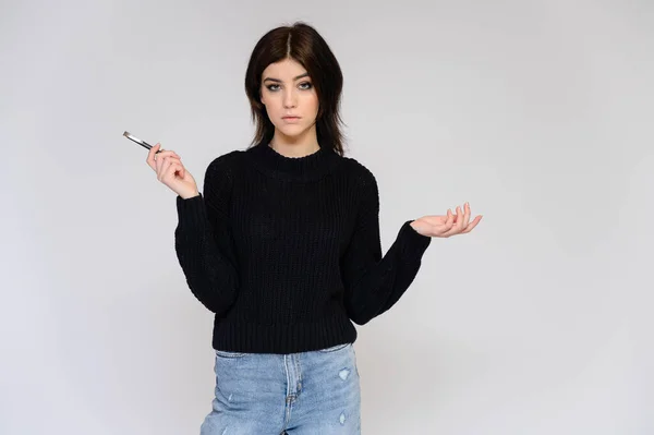 Retrato de uma jovem estudante bonita com cabelo preto longo, em um fundo branco. Ele fica bem na frente da câmera, mostrando suas mãos em poses diferentes com emoções diferentes. . — Fotografia de Stock