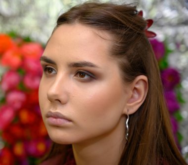 Kozmetik konsepti, yüz bakımı. Makyaj yaparken uzun siyah saçlı ve mükemmel makyajlı güzel bir kızın yakın plan portresi. Güzellik uzmanı bir makyajcının işi..