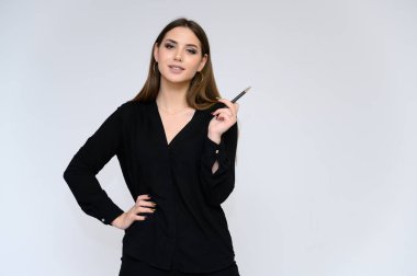 Beyaz bir arka planda, iş elbisesi içinde uzun siyah saçlı, güzel bir sekreterin yakın plan portresi. Farklı pozlarda kameranın önünde durarak..