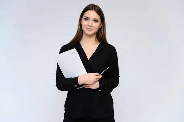 Retrato de cerca de una joven secretaria guapa con el pelo negro largo en un traje de negocios, sobre un fondo blanco. De pie justo delante de la cámara en diferentes poses con emociones . — Foto de Stock