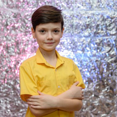 Genç çocuk için tatil fotoğrafı konsepti. Sarı gömlekli parlak bir arka planda bir erkek bebeğin portresi. Farklı pozlarda kameranın önünde duruyor. Duygularıyla..