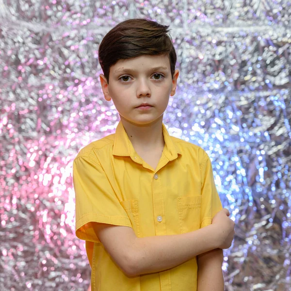 Φωτογραφία διακοπών για έφηβο αγόρι. Πορτραίτο ενός αγοριού σε ένα λαμπερό φόντο σε ένα κίτρινο πουκάμισο. Στέκεται μπροστά στην κάμερα σε διαφορετικές στάσεις με συναισθήματα. — Φωτογραφία Αρχείου