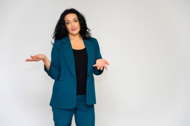 Beyaz bir arka planda uzun kıvırcık saçlı, iş elbisesi içinde güzel esmer bir kadının portresi. Kameranın önünde duruyor, gülümsüyor, çeşitli pozlarda konuşuyor..