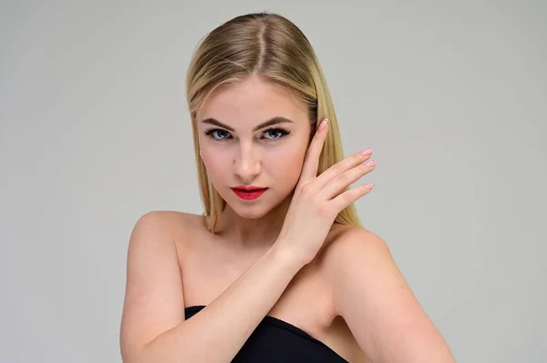 Concepto cosmético, rejuvenecimiento de la piel. Retrato de cerca de una hermosa modelo rubia sobre un fondo blanco con pelo largo, excelente maquillaje, cara y labios hermosos . — Foto de Stock