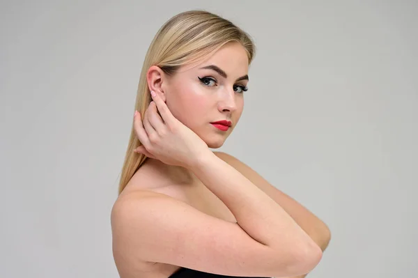 Concept cosmetisch, huidverjonging. Close-up portret van een mooi blond model op een witte achtergrond met lang haar, uitstekende make-up, mooi gezicht en lippen. — Stockfoto