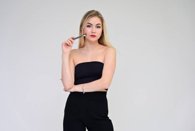 Bir sekreterle iş eğitimi konsepti. Beyaz bir arka planda, uzun saçlı, harika makyajlı şık, güzel bir sarışın mankenin portresi..