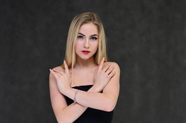 El concepto de glamour de moda, cosméticos y belleza con una chica bonita. Retrato de una modelo rubia hermosa de moda con el pelo largo, gran maquillaje, sobre un fondo gris . — Foto de Stock