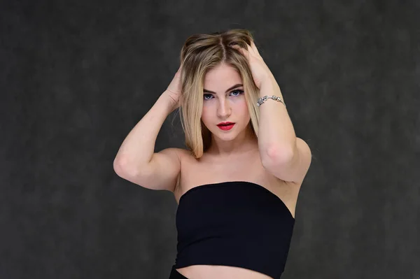 Das Konzept der modischen Glamour, Kosmetik und Schönheit mit einem hübschen Mädchen. Porträt einer modischen schönen blonden Model mit langen Haaren, tolles Make-up, auf einem grauen Hintergrund. — Stockfoto