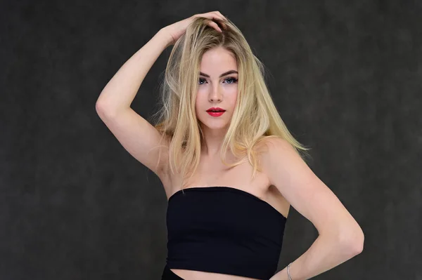 Das Konzept der modischen Glamour, Kosmetik und Schönheit mit einem hübschen Mädchen. Porträt einer modischen schönen blonden Model mit langen Haaren, tolles Make-up, auf einem grauen Hintergrund. — Stockfoto