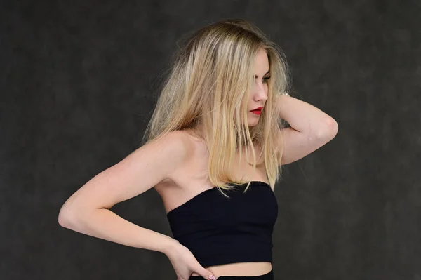 Het concept van modieuze glamour, cosmetica en schoonheid met een mooi meisje. Portret van een modieus mooi blond model met lang haar, geweldige make-up, op een grijze achtergrond. — Stockfoto