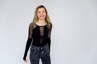 Bir kadının kameraya konuşması fikri. Beyaz arka planda siyah tişörtlü, uzun, kıvırcık saçlı güzel bir kızın fotoğrafı kameranın önünde duruyor..