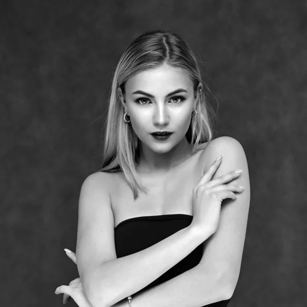 Concept art of beauty, glamor and cosmetics. A large portrait in black and white style of a beautiful model girl with combed hair and bright excellent makeup on a gray background. — ストック写真