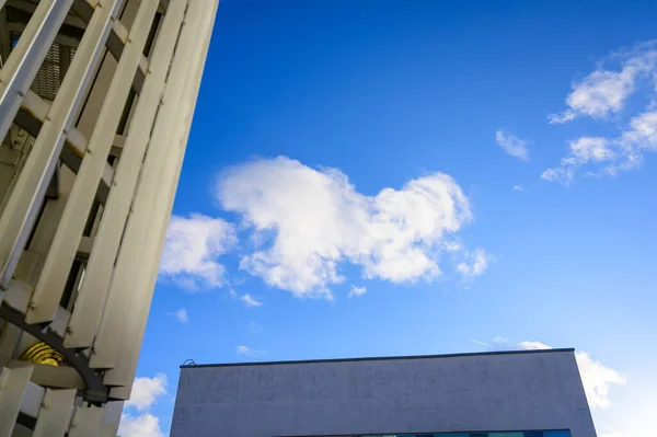 照片上是一座美丽的蓝天，阳光明媚，建筑的背景 — 图库照片