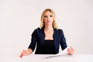 İş konsepti. Güzel bir kadın muhasebeci portresi - mükemmel makyajlı, beyaz arka planda güzel saçı olan, elinde klasörle bir masada oturan.