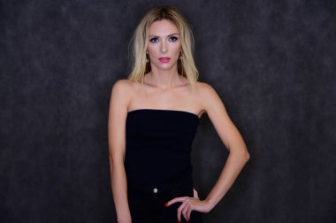 Oldukça ince, sarışın bir modelin sanatsal portresi mükemmel makyajlı ve gri arka planda siyah bluzlu güzel saçlı. Şık, modaya uygun, genç, seksi. Bu farklı pozlarda..
