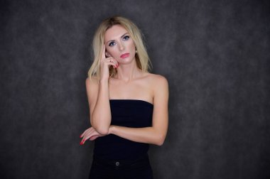 Oldukça ince, sarışın bir modelin sanatsal portresi mükemmel makyajlı ve gri arka planda siyah bluzlu güzel saçlı. Şık, modaya uygun, genç, seksi. Bu farklı pozlarda..