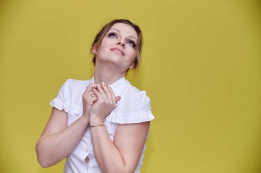İş konsepti. 40 yaşında, güzel, yetişkin bir kadının portresi. Sarı arka planda iş elbisesi içinde güzel bir makyajı var. Gülümseyerek kameranın önünde duruyorsun..