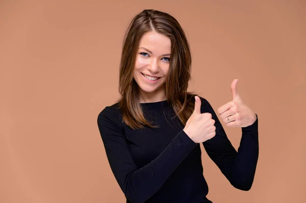 Conceito de uma jovem com um sorriso de dentes brancos. Close-up Retrato de uma menina bonita em uma camiseta preta com dentes bonitos. Sorrindo, mostrando emoções em um fundo rosa . — Fotografia de Stock