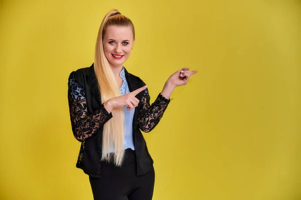 Retrato de una mujer gerente en un traje de negocios con pelo largo y hermoso y excelente maquillaje sobre un fondo amarillo. Concepto de negocio rubia chica de pie delante de la cámara . — Foto de Stock