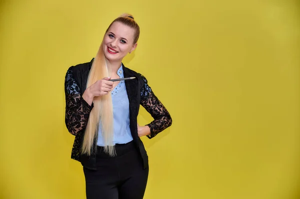 Portret van een manager vrouw in een zakenpak met lang mooi haar en uitstekende make-up op een gele achtergrond. Concept business blond meisje staat voor de camera. — Stockfoto