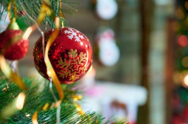 Yeni yıl ve Noel konsepti. Yılbaşı tatilinde yılbaşı ağacı için arka planda süslemelerin şenlikli fotoğrafı.