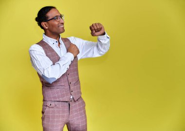 Kısa saçlı, beyaz dişli, sarı arka planda iş elbisesi giymiş genç bir Afro-Amerikan 'ın portresi. Kameranın önünde dikilip konuşmak..