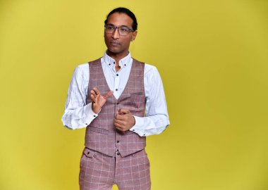 Kısa saçlı, beyaz dişli, sarı arka planda iş elbisesi giymiş genç bir Afro-Amerikan 'ın portresi. Kameranın önünde dikilip konuşmak..